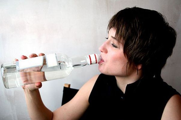 женщина пьет водку из горла